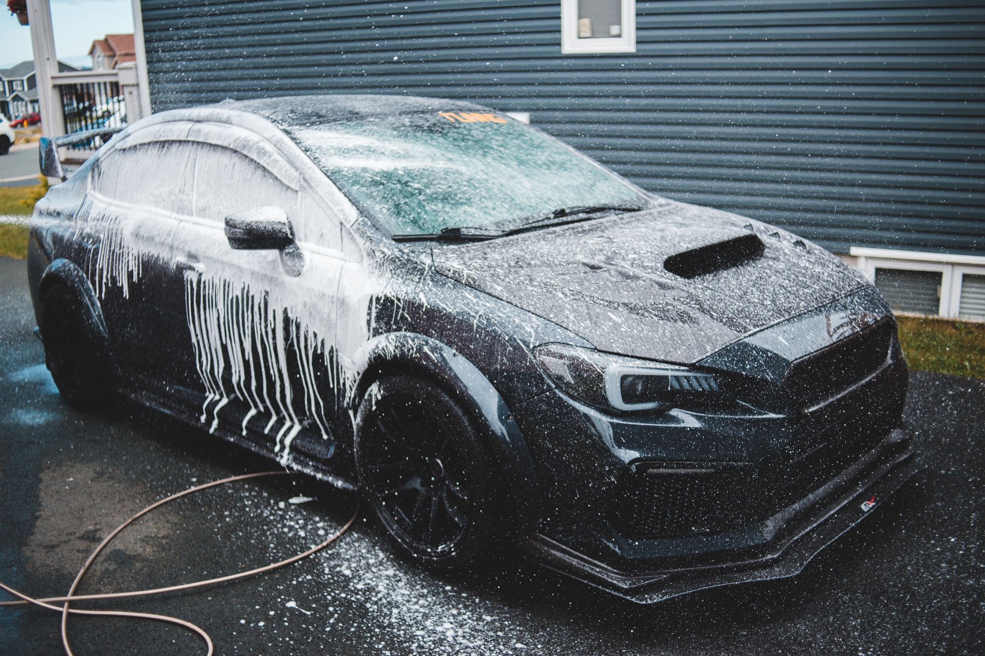 A vehicle being cleaned with water and foam