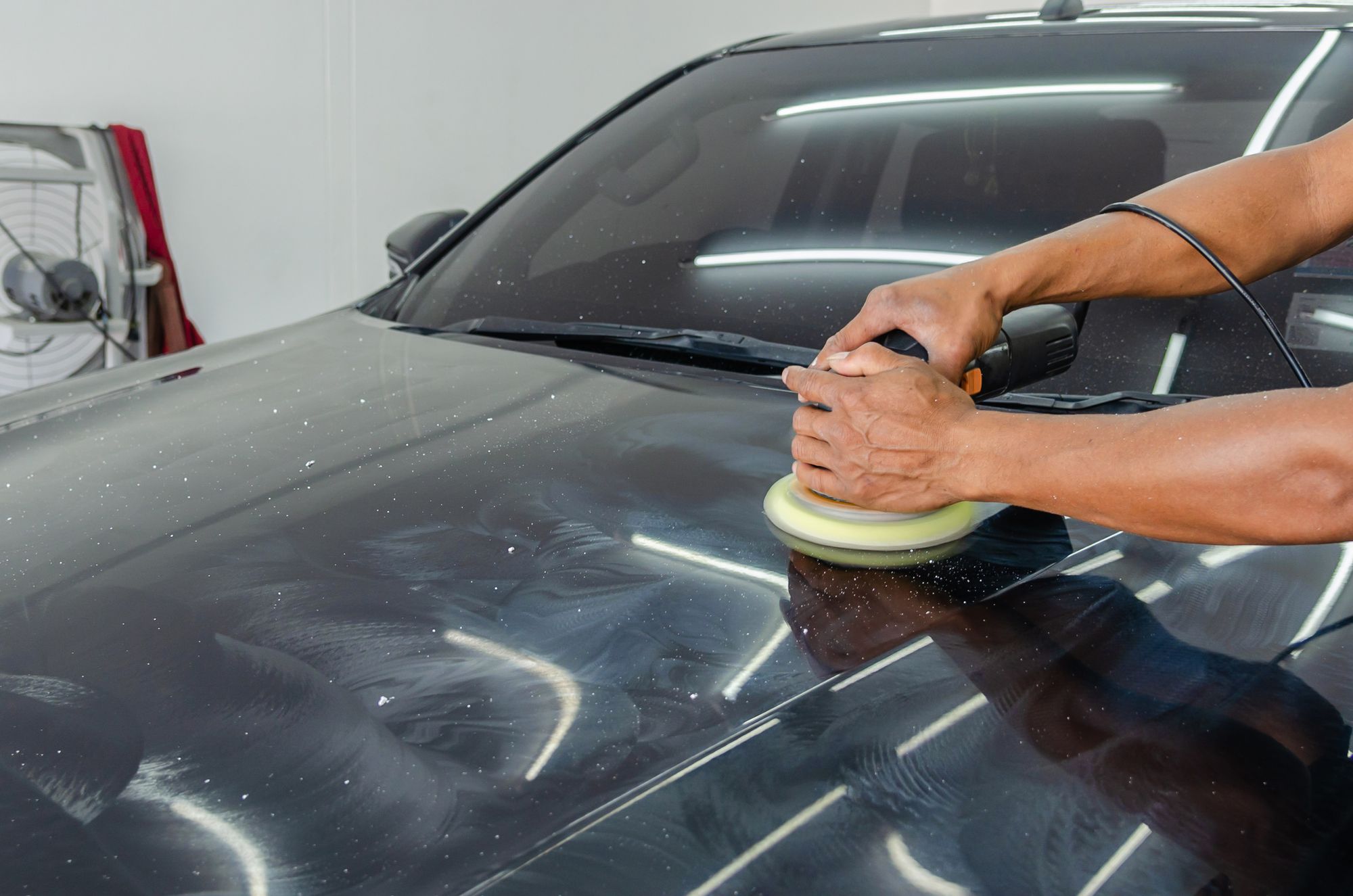 Close-up of careful automotive paint polishing and finish care